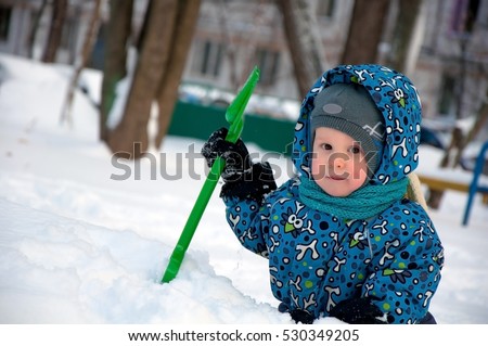 Portrait of adorable baby holding snow shovel