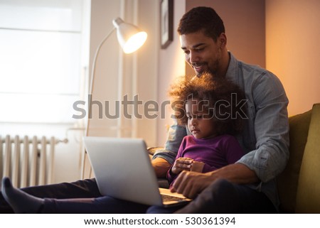 African american dad and his daughter using laptop together.