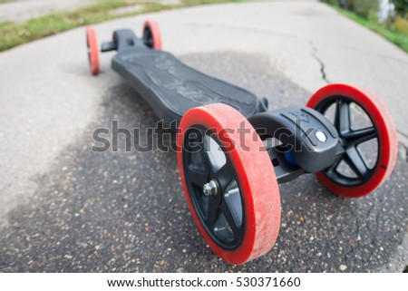 modern longboard with big red wheel on the asphalt road