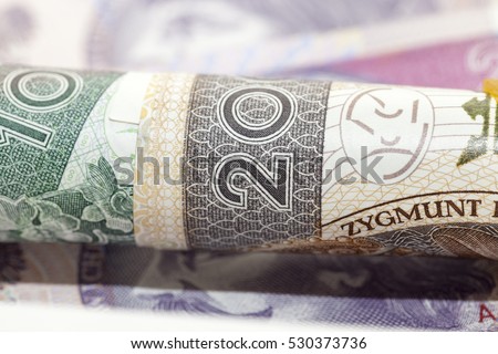   Polish banknotes photographed close-up. Shown details of bills. International designation - PLN. Money rolled into a tube