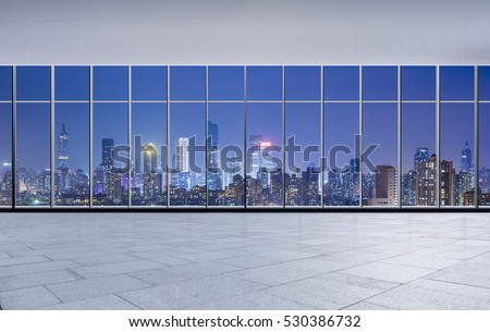 Panoramic skyline and buildings at night from glass window