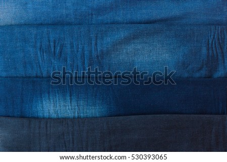 Pile of different jeans or denim texture background