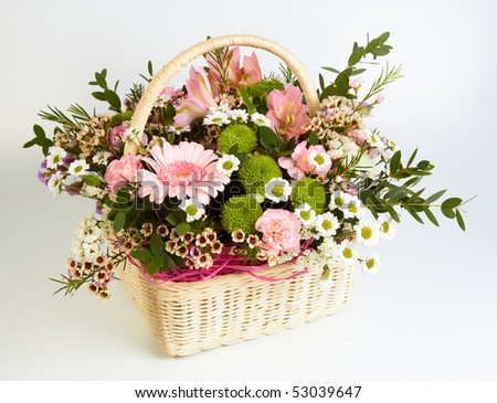 Bouquet of flowers in basket on white background