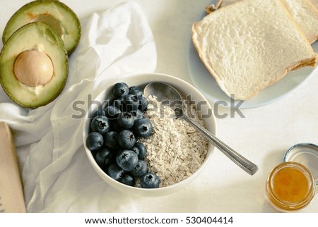 Oat with blueberry, avocado, soft bread and marmalade.