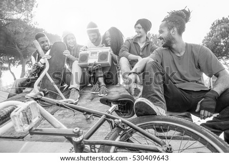 Happy friends listening music in new york skate city park - Breaker,skaters and freestyle bikers having fun - Concept of sporty people socializing - Focus on rasta man - Black and white editing