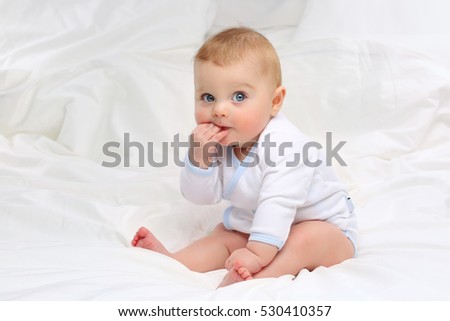 Baby in white bedding. Royalty-Free Stock Photo #530410357