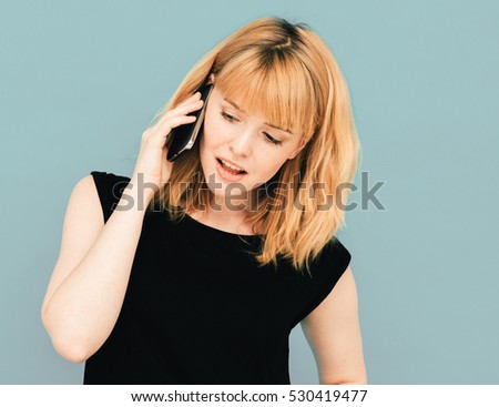 Young beautiful woman using mobile phone studio on gray color background