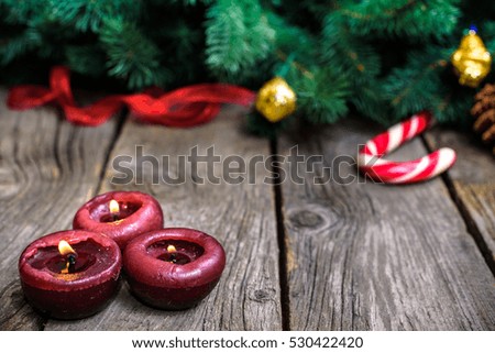 Christmas wooden background with snow fir tree. View with copy space. Burning round candles..