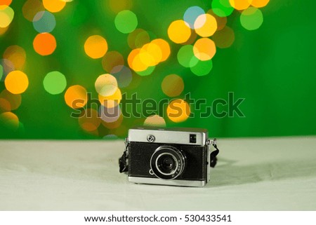 The old film camera on a green background with flowers blur bokeh