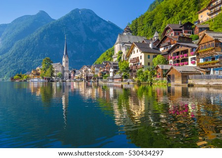 Scenic picture-postcard view of famous Hallstatt lakeside town reflecting in Hallstattersee lake in the Austrian Alps in beautiful morning light on a sunny day in summer, Salzkammergut region, Austria Royalty-Free Stock Photo #530434297