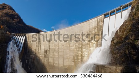 Dam of Contra Verzasca Ticino, Switzerland: spectacular waterfalls from the overflow of the lake over the dam Royalty-Free Stock Photo #530464468