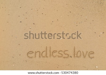 written words "endless love" on sand of beach