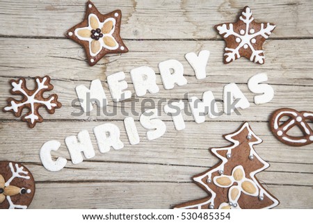 Christmassy grey wood background with gingerbread and Merry Christma's letter