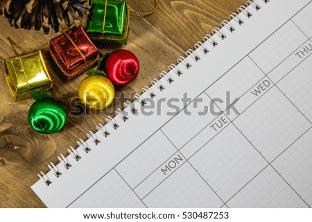 Calendar and gift boxes for Christmas On brown wood background.