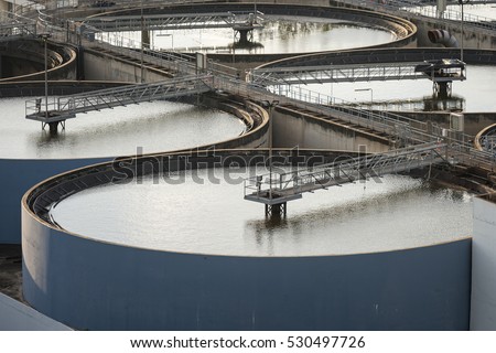Modern urban wastewater treatment plant.Water purification is the process of removing undesirable chemicals, suspended solids and gases from contaminated water. Water cleaning facility outdoors.  Royalty-Free Stock Photo #530497726