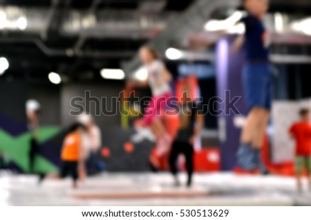 Blurred background. Young people and kids  jumping on a trampoline. 
