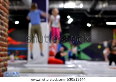 Blurred background. Young people and kids  jumping on a trampoline. 