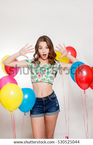 people, teens, holidays and party concept - happy smiling pretty teenage girl with helium balloons over gray background. woman surprised