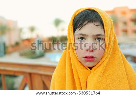 preteen boy in towel on water park background