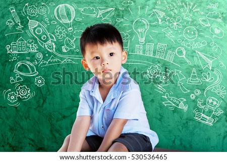 Little boy thinking many ideas with set of infographics over green  chalkboard background with freehand doodle