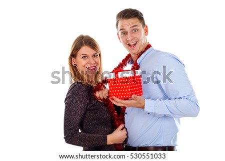 Picture of a cute couple holding Christmas decorations and gift