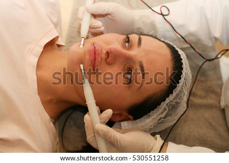 Young woman having facelift in beauty salon.