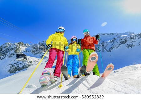 Skiing family enjoying winter vacation on snow in sunny cold day in mountains and fun. Switzerland, Alps