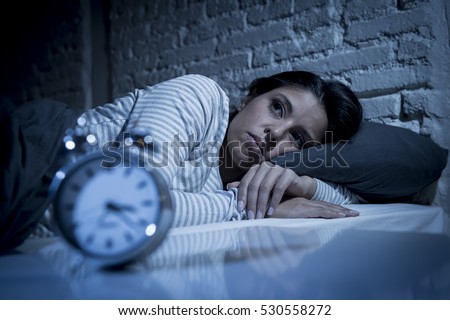 young beautiful hispanic woman at home bedroom lying in bed late at night trying to sleep suffering insomnia sleeping disorder or scared on nightmares looking sad worried and stressed Royalty-Free Stock Photo #530558272