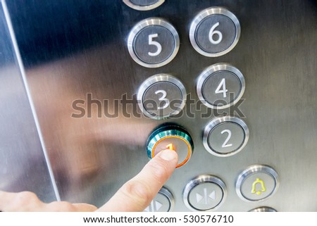 The hand presses on the first floor elevator button Royalty-Free Stock Photo #530576710