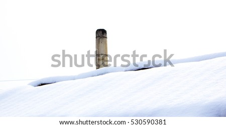 Chimney in red bricks with white snow on roof. Detailed view from Sweden.