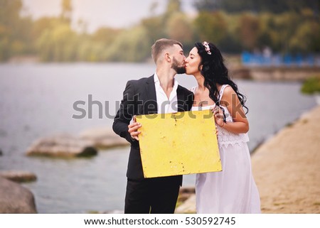 A sign for text in the hands of beautiful couple.