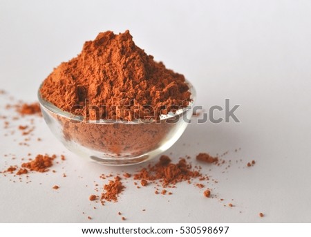 Red clay powder Montmorillonite in a glass bowl isolated