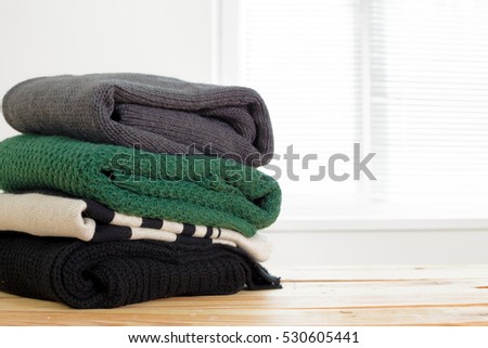 Stack of white cozy knitted sweaters 
