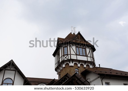 Look from below at wooden tower hanging over the house