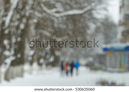 People on the streets of the city. Snow. Blurred picture
