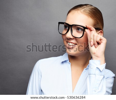 happy smiling young business woman in glasses, over grey  backgr