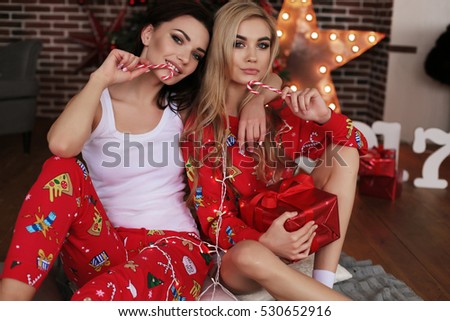 fashion interior holiday Christmas photo of beautiful women in cozy home clothes celebrating New Year holidays