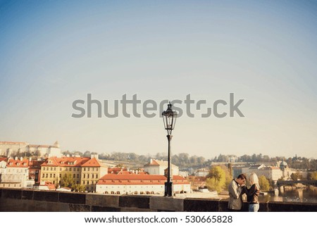 young and happy woman and man standing on the bridge