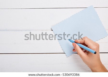 Hand with pen writing on a paper sheet. Overhead point of view. Modern flat design concept