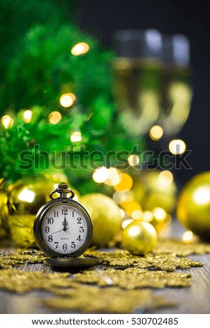 Midnight celebration of the new year with pocket watch and champagne glasses