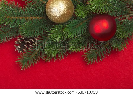 Christmas tree branches with decorations on a red background