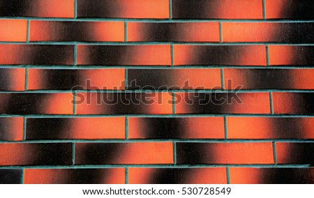 Gradient texture of brick wall with black and orange colors. A scratched background with imitation of brick. Green grid lines between wall tiles. Gradient backdrop.