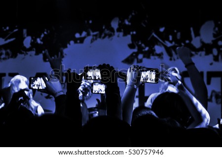 Phone in hand to record video at a concert. Stream