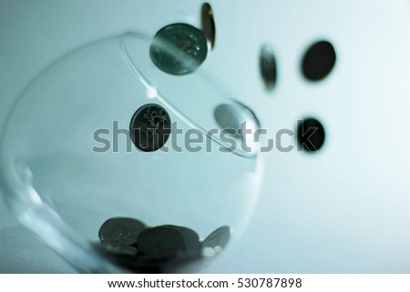coins falling into the clear jar