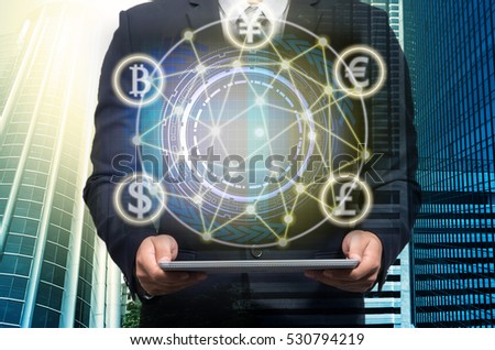 Businessman holding the laptop with Currencies sign symbol of Fintech technology over the Network connection of cityscape background, Investment Financial Internet Technology Concept