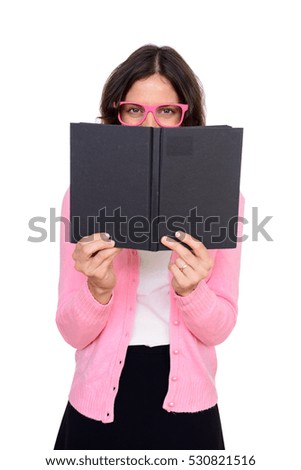 Studio shot of happy Caucasian woman hiding behind book isolated against white background