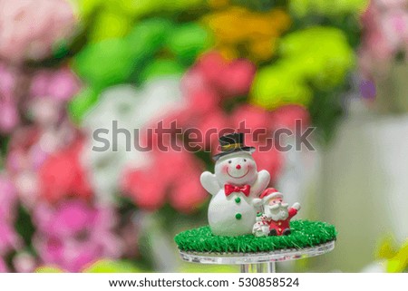 A snow man and Santa Claus greeting doll in Christmas festival with blur background.