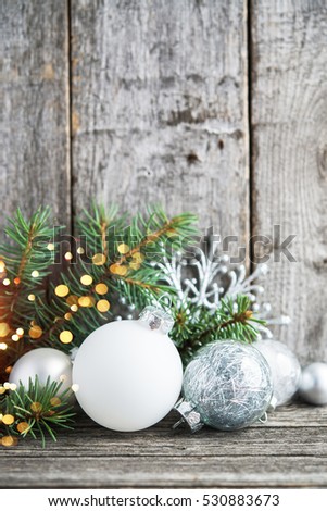 Silver and white christmas ornaments, xmas tree on rustic wood background with sparkle bokeh lights. Merry christmas greeting card. Winter holiday theme. Happy New Year.