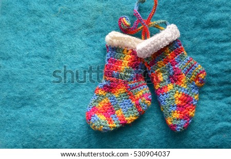 Handmade knitting socks with ornament hanging on ribbon. Christmas handmade decorations. Christmas colored boots in anticipation of Santa's gifts. Colorful Christmas stocking decoration element.