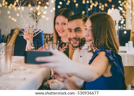 Friends making selfie while celebrating Christmas or New Year eve. Toned picture